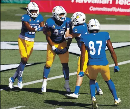  ?? PHOTOS BY MARCO GARCIA – THE ASSOCIATED PRESS ?? San Jose State running back Tyler Nevens, second from left, celebrates with teammates after scoring a first-quarter touchdown against Hawaii.