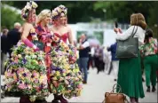  ?? DANIEL LEAL / AFP ?? A visitor poses for a photograph with women wearing flower-themed dresses at the 2022 RHS Chelsea Flower Show in London on May 23. Nearly 140,000 people are expected to attend the west London show that will run until May 29. The flower show is held annually in the grounds of the Royal Hospital Chelsea.