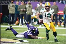  ?? BRUCE KLUCKHOHN / AP ?? Green Bay Packers quarterbac­k Aaron Rodgers (12) runs from Minnesota Vikings defensive tackle Dalvin Tomlinson (94) during an NFL game Sunday in Minneapoli­s.