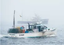  ?? ROBERT F. BUKATY/AP ?? Lobster fishing boats head out to sea on a foggy morning off South Portland, Maine, in July 2018.