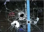  ?? AP PHOTO/MICHAEL PEREZ ?? A storefront window with bullet holes is seen at the scene of a fatal overnight shooting on South Street in Philadelph­ia on Sunday.