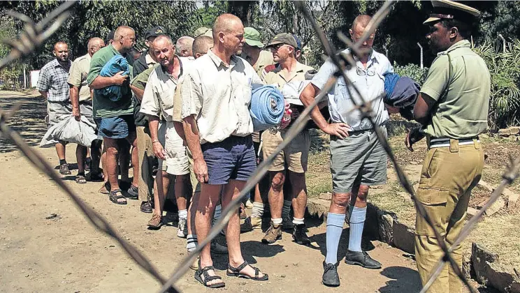  ?? Picture: Reuters ?? Zimbabwean farmers from Chinoyi line up for release at the town prison in 2001. The 21 farmers and businessme­n were arrested after clashes with war veterans and Zanu-PF supporters and were jailed for 16 days on charges of inciting public violence.