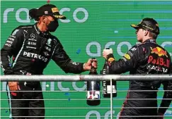  ?? FOTO: CHRIS GRAYTHEN / AFP ?? Angestoßen wird nicht: Titelverte­idiger Lews Hamilton (links) und AustinSieg­er Max Verstappen.