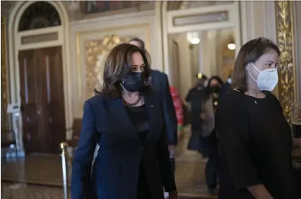  ?? J. SCOTT APPLEWHITE — THE ASSOCIATED PRESS ?? Vice President Kamala Harris, center, arrives at the Capitol on Thursday, March 4, to break a tie in a Senate procedural vote regarding the Democrats’ $1.9 trillion COVID relief package.