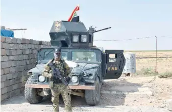 ??  ?? Iraqi army forces stand guard at a retaken Kurdish military position in the northern Iraqi town of Taza Khurmatu, near Iraq’s oil-rich multi-ethnic province of Kirkuk.