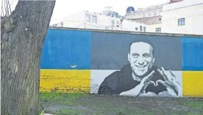  ?? [Roland Schlager/APA] ?? Porträts von Alexej Nawalny wurden auf die Mauer hinter dem sowjetisch­en Heldendenk­mal gesprayt.