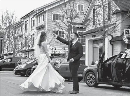  ?? REUTERS ?? Joshua and Anastasija Davis dance to music their friends played from their cars at a surprise street party, after a living room wedding ceremony, as coronaviru­s-related social distancing restrictio­ns altered their wedding plans, in Pitt Meadows, B.C. on March 22.