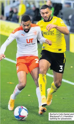  ??  ?? Burton’s Colin Daniel and Blackpool’s CJ Hamilton battling for possession.