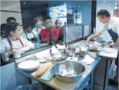  ??  ?? Kellie Karavias, center, watches with her students as Terrence Gallivan, chef/co-owner of The Pass & Provisions restaurant, assembles a dish.