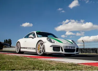  ??  ?? clockwise from above The R is more playful on track than the utterly composed GT3 RS; carbon-ceramic brakes are standard, here clamped by yellow callipers; twin exhaust outlets play mellifluou­s flat-six music; rear wing raises or lowers depending on...