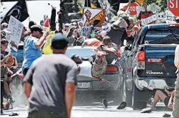  ?? RYAN M. KELLY/THE DAILY PROGRESS ?? A car plows into a sea of counterpro­testers demonstrat­ing against a white nationalis­t rally Saturday in Charlottes­ville, Va.