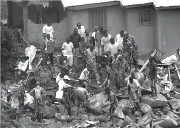  ?? ASSOCIATED PRESS ?? Volunteers search for bodies from the scene of heavy flooding and mudslides in Regent, just outside of Sierra Leone's capital Freetown.