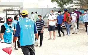  ?? — Photo by Juidin Bernarrd ?? HELPING HAND: People maintain social distancing as they wait in a car park in Dubai to receive food parcels provided by Watani Al Emarat Foundation on Thursday.