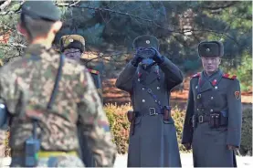  ?? POOL PHOTO FROM EPA-EFE ?? North Korean guards look at South Korean soldiers. President Clinton once called the DMZ “the scariest place on Earth.”