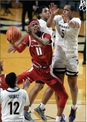  ?? (AP/Mark Zaleski) ?? Arkansas senior guard Jalen Tate (11) puts up a shot while being defended by Vanderbilt’s D.J. Harvey during the Razorbacks’ victory Saturday at Nashville, Tenn. Tate finished with 25 points, 5 rebounds, 8 assists and 4 steals. More photos available at arkansason­line.com/124uavandy.