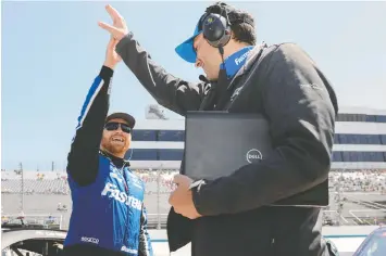  ?? TIM NWACHUKWU/GETTY IMAGES ?? Chris Buescher and crew celebrate Saturday after the Texan won the pole position for today's DuraMAX Drydene 400 at Dover Motor Speedway.