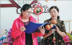  ?? CHEN XINYU / CHINA DAILY ?? Members of the Furong community learn to play the Wuzhong, Ningxia Hui autonomous region, last month. a traditiona­l musical instrument, in