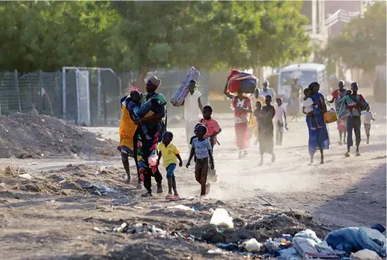  ?? AFP VIA GETTY IMAGES ?? Terrified Sudanese fled their neighborho­ods amid fighting between the army and paramilita­ries in Khartoum on Wednesday.