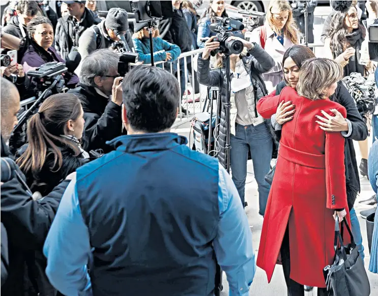  ??  ?? Ambra Gutierrez, who accused Harvey Weinstein of groping her, embraces attorney Gloria Allred (red coat), who represente­d three of the six women