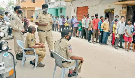  ?? P.SURENDRA ?? Police helplessly watch as people ignore social distancing norms at Malakpet Paltan for free ration being supplied at Government Fair Price shops on Saturday. With servers down for a significan­t amount of time, there were lot of arguments with the police and Fair Price shop owners.
—