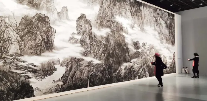  ??  ?? Visitors take pictures of a large Chinese painting depicting undulating mountains and rivers which is created in the Tang Dynasty (AD 618- 907) at the Zhejiang Exhibition Hall. The “Tang Dynasty Poems Road in Eastern Zhejiang” exhibition will run through February 26. — All photos by Wu Huixin