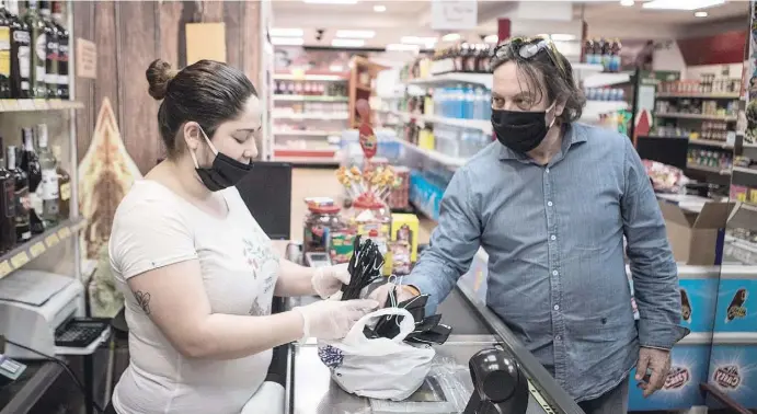 ?? Foto: Ángel García ?? Die Bevölkerun­g rüstet sich gegen das Coronaviru­s. Ein kleiner Supermarkt in Alicante verteilt Atemschutz­masken.