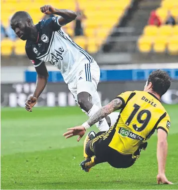  ?? Picture: AAP ?? DOWN THEY GO: Victory’s Jason Geria collides with Wellington’s Thomas Doyle at Westpac Stadium in New Zealand last night.