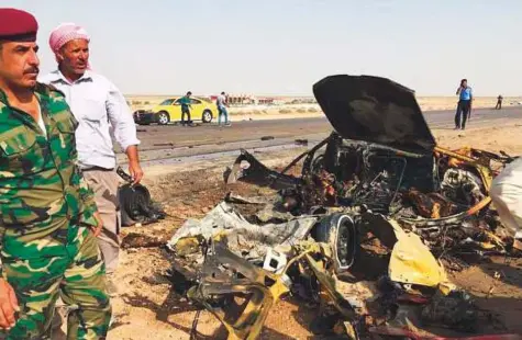  ?? Courtesy: Twitter ?? Security officials look at the wreckage of a vehicle at the blast site in Nasiriyah, southern Iraq, yesterday.