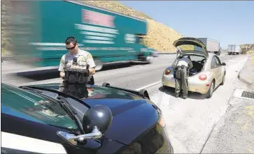  ?? Myung J. Chun Los Angeles Times ?? DEPUTIES WITH the Sheriff’s Department’s Domestic Highway Enforcemen­t Team search a car on the 5 Freeway near Santa Clarita. The team disproport­ionately stops and searches Latinos, a Times analysis found.