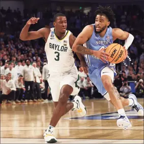  ?? Tom Pennington / Getty Images ?? North Carolina’s R.J. Davis, right, drives with the ball as Baylor’s Dale Bonner defends in overtime of their second-round NCAA Tournament game Saturday.