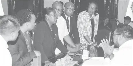  ??  ?? Public Accounts Committee members along with Finance Secretary Hector Butts (standing, second from right) and Accountant General Jennifer Chapman (standing, at right) in consultati­on with committee Chairman Irfaan Ali (seated at right) prior to the announceme­nt that they would not go on with the examinatio­n of Region Five’s accounts.