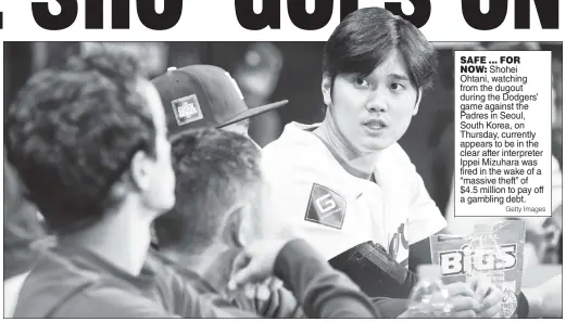  ?? Getty Images ?? SAFE ... FOR NOW: Shohei Ohtani, watching from the dugout during the Dodgers’ game against the Padres in Seoul, South Korea, on Thursday, currently appears to be in the clear after interprete­r Ippei Mizuhara was fired in the wake of a “massive theft” of $4.5 million to pay off a gambling debt.