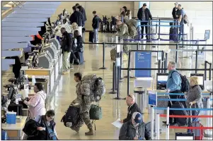  ?? Arkansas Democrat-Gazette/STATON BREIDENTHA­L ?? Travelers check in for flights Friday at Bill and Hillary Clinton National Airport/Adams Field as Thanksgivi­ng holiday travel ramps up.