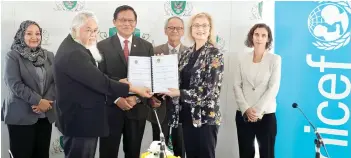  ?? — Photo by Chimon Upon ?? Khaidir (second left) and Saranovic seen exchanging documents after signing the MoU at the DBKU headquarte­rs. Also seen are Dr Abdul Rahman (third left), Noriah (left), Junaidi (third right) and Dr Juanita (right).