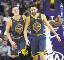  ??  ?? The Warriors’ Jonas Jerebko (21) and Klay Thompson celebrate after Jerebko banked in a 3-pointer.