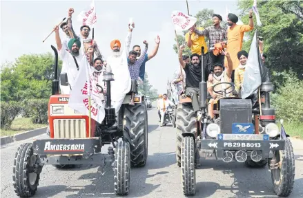  ?? AFP ?? Farmers shout slogans from their tractors during a nationwide strike against the central government’s agricultur­al reforms on the outskirts of Amritsar late last month.