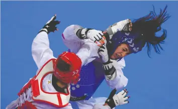  ?? LUIS ACOSTA/AFP/GETTY IMAGES ?? Skylar Park (in blue) competes in the Taekwondo Women’s Under 57kg Final during the Pan-American
Games Lima 2019, at which she won the silver medal.