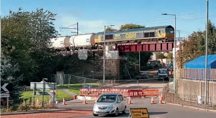  ?? DAVID HALL ?? Following last issue’s report into bridge bashes by lorries, this shot shows the rail bridge over the A73 at Bellside (near Cleland, North Lanarkshir­e) which has recently been raised from 4.3m to 5.1m. Crossing over the new bridge on October 6 is GBRf ’s No. 66741 with the Fort William to North Blyth empty alumina tanks.