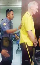  ??  ?? LIFE SENTENCE FOR AUSSIE – Rapist and human trafficker Peter Gerard Scully, an Australian, is being escorted by police officers from the Hall of Justice in Cagayan de Oro City after the trial that sentenced him and his cohort to life imprisonme­nt on...