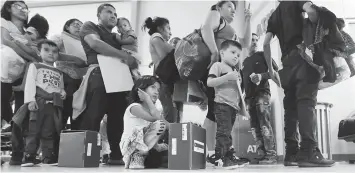  ?? (AP) ?? Immigrant families seeking asylum wait in line at the central bus station after they were processed and released by US Customs and Border Protection in McAllen, Texas.