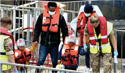  ?? ?? Perilous: Two small children wearing matching beanie hats were among yesterday’s arrivals