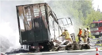  ??  ?? Firefighte­rs work at the site where a coach burst into flames after colliding with a lorry on a motorway near Muenchberg in this still image taken from video. — Reuters photo