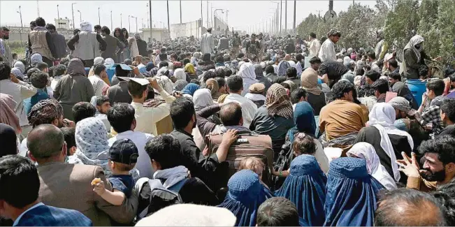  ??  ?? KABUL. La multitud se agolpa en el aeropuerto de al capital afgana con la esperanza de abordar algún avión; los talibanes bloquean los acceso a la terminal; las escenas de caos se repiten desde el domingo.