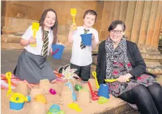  ??  ?? Life’s a beach Christie Thomson, 10 , and Blayre Donnelly, also10 , from St Fergus’ Primary, in Paisley, making sandcastle­s with Councillor Lisa-Marie Hughes