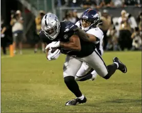  ?? AP photo ?? Raiders wide receiver Tyrell Williams scores a touchdown as he’s defended by Broncos free safety Justin Simmons in the first quarter of Oakland’s 24-16 victory over Denver on Monday.