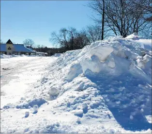  ?? LINDA GIRARDI/BEACON-NEWS ?? Snow is piled high alongside a parking lot near the Geneva train station.