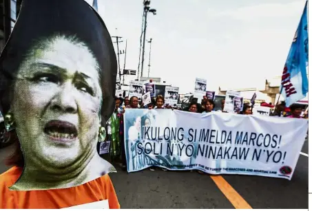  ??  ?? Crying out loud: Protesters displaying a banner as they picket at the anti-graft Sandiganba­yan court. The banner says: ‘Jail Imelda Marcos! Return The Ill-gotten Wealth!’ — AP