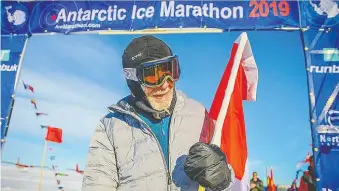  ??  ?? Roy Svenningse­n, 84, set a world record this month by becoming the oldest runner to finish a 42-kilometre marathon in Antarctica. He is seen here crossing the finish line with a Canadian flag a spectator handed him.