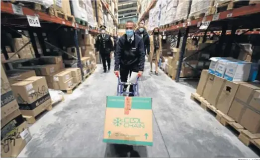  ?? ANTONIO L. JUÁREZ ?? Un operario traslada una caja de viales de Pfizer en el almacén de Bidafarma de Granada.