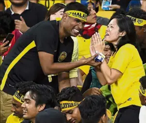  ??  ?? Love is in the air: A Malaysia supporter proposing to his girlfriend during the match against Myanmar at the National Stadium in Bukit Jalil. — Bernama